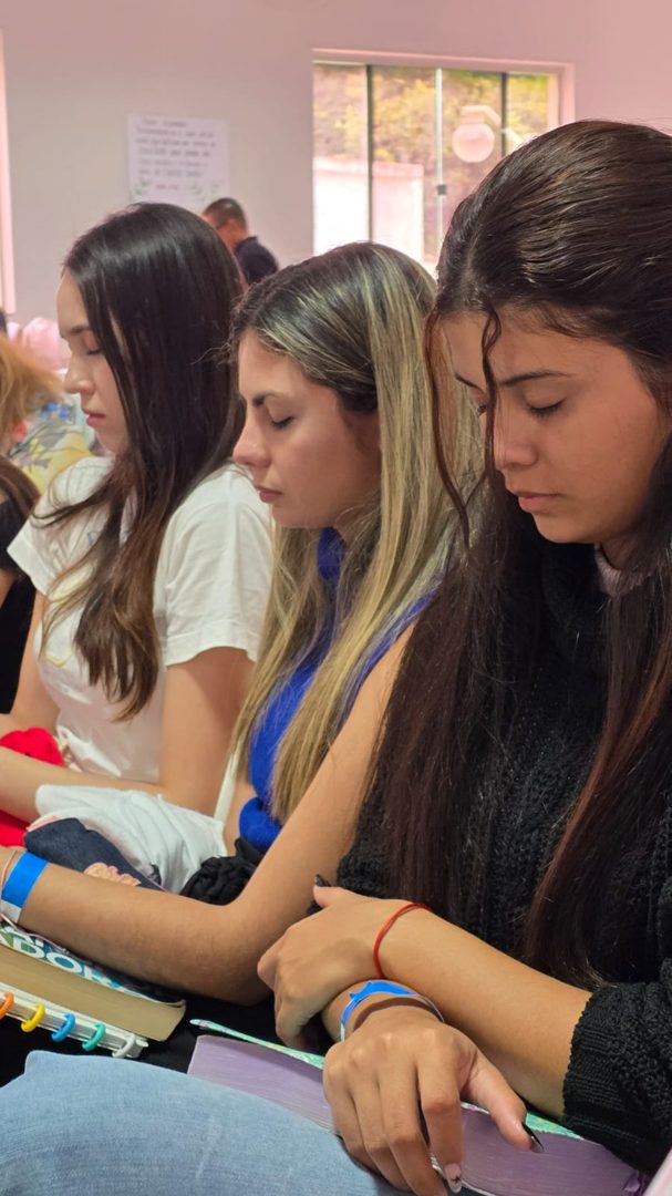 Jovens em oração durante o Culto de Jovens